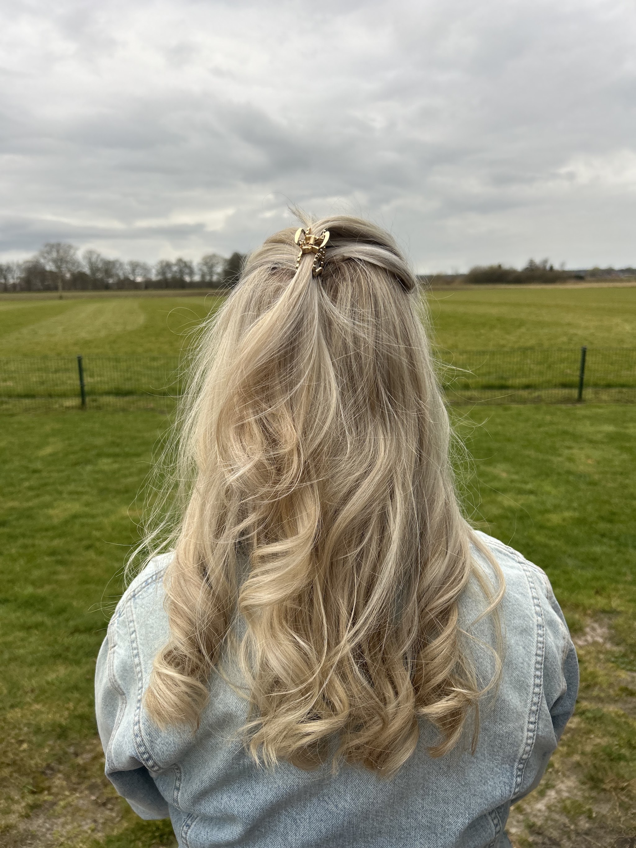 Lang blond haar met zachte krullen, geknipt en gekleurd bij Haarstudio 16